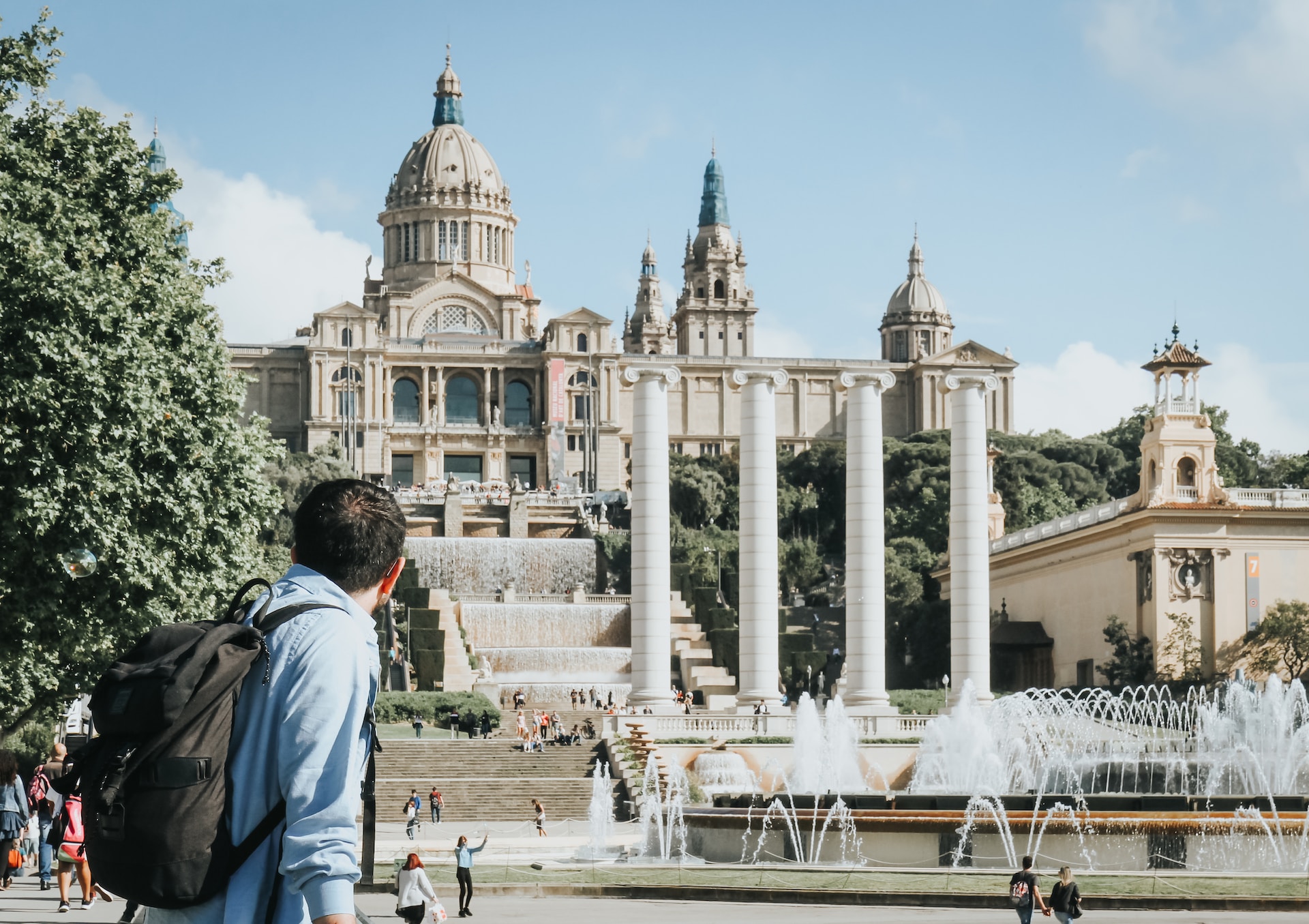 Tourist with a backpack looking at a domed palace and fountains